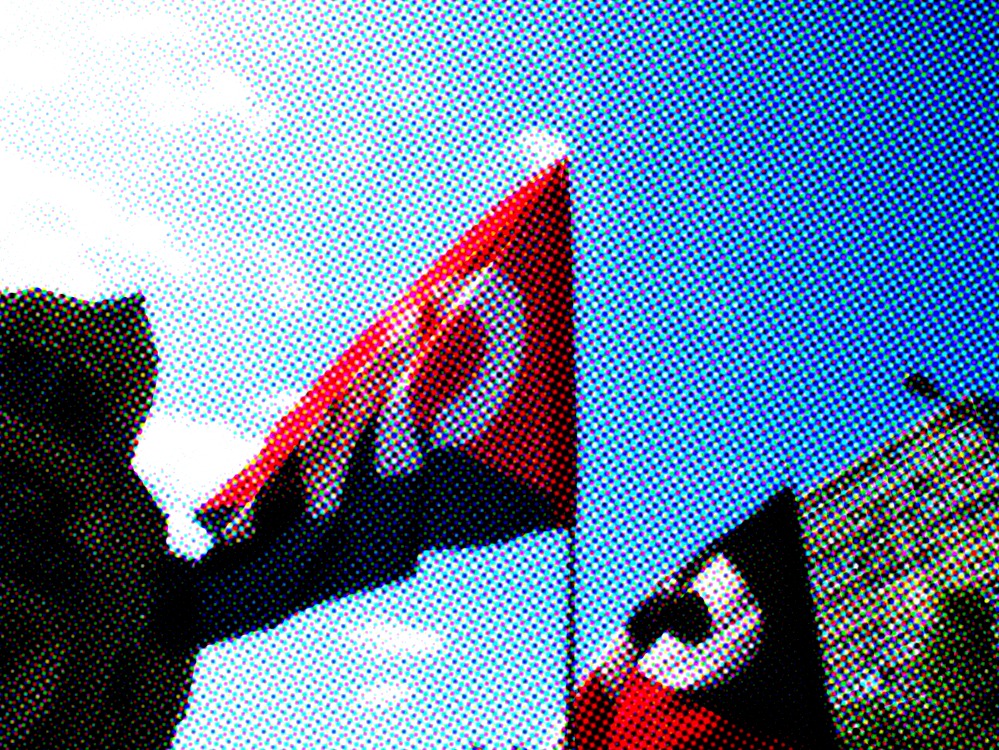 Deux drapeaux CNT dans le ciel de Rennes, avec un traitement graphique qui évoque l'impression offset.